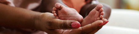 Photo for Closeup image of mother holding feet of little baby - Royalty Free Image