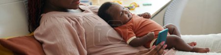 Téléchargez les photos : Bannière Web avec mère assise sur le lit avec bébé et amis textos - en image libre de droit