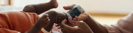 Foto de Banner web de la madre poniendo calcetines en los pies del pequeño bebé - Imagen libre de derechos