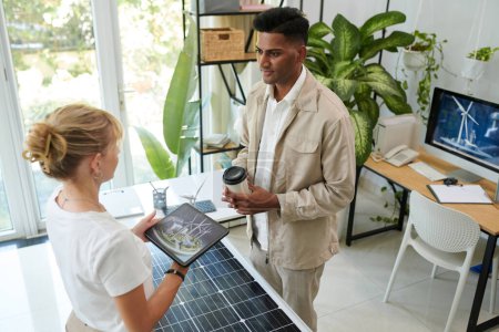 Photo for Wind and solar renewable energy sales manager talking to client and showing project visualization - Royalty Free Image