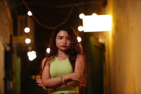 Téléchargez les photos : Portrait de jeune femme vietnamienne debout dans le couloir de vieux bâtiments éclairer avec des lumières tamisées - en image libre de droit