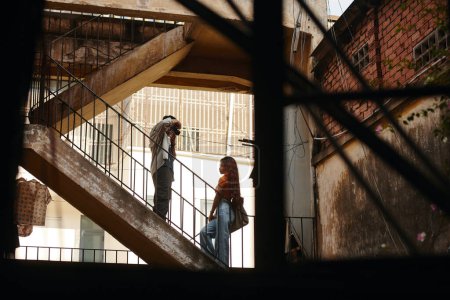 Téléchargez les photos : Jeune femme posant pour photographe sur les marches d'un vieux bâtiment abandonné - en image libre de droit