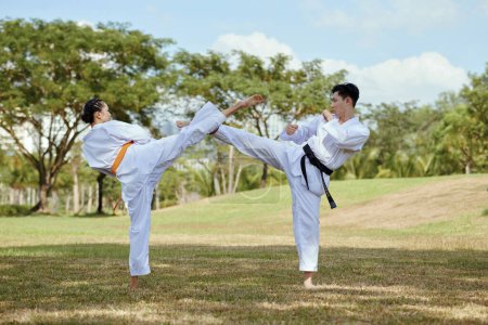 Foto de Lucha contra los atletas taekwondo haciendo patada alta lateral - Imagen libre de derechos