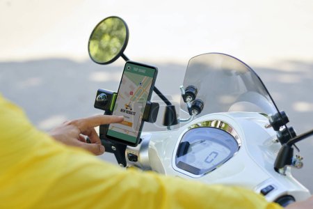 Téléchargez les photos : Chauffeur de taxi moto acceptant une nouvelle demande via une application mobile - en image libre de droit