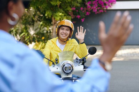 Photo for Motorbike taxi driver greeting passenger - Royalty Free Image