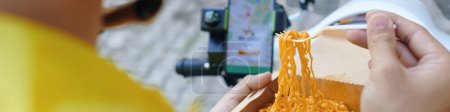 Téléchargez les photos : En-tête avec chauffeur de taxi moto manger le déjeuner et vérifier les nouvelles demandes notifications - en image libre de droit