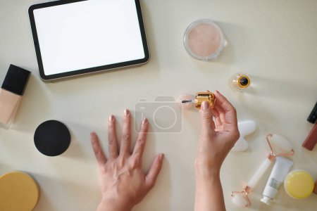 Téléchargez les photos : Mains de femme regardant des vidéos sur tablette lors de la manucure à la maison, vue du dessus - en image libre de droit