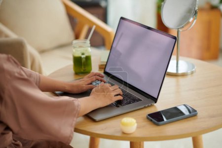 Téléchargez les photos : Image recadrée de la femme en robe de satin travaillant sur ordinateur portable - en image libre de droit