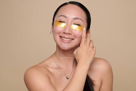 Photo for Portrait of happy excited young woman applying hydrogel patches - Royalty Free Image