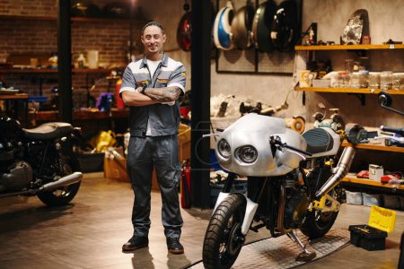 Photo for Portrait of smiling repairman working in motorcycle garage - Royalty Free Image