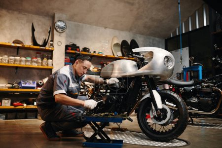 Réparateur choisir outil lors de la fixation de la moto dans son atelier de réparation