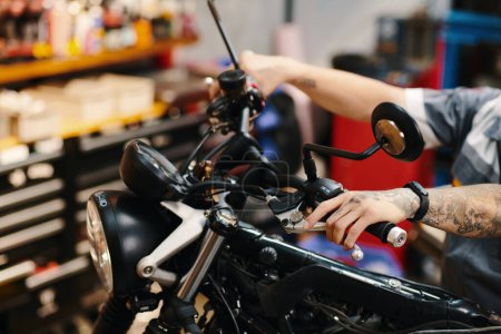 Photo for Cropped image of repairman fixing motorcycle handlebar - Royalty Free Image