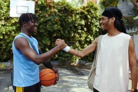 Téléchargez les photos : Amis serrant la main avant le match de streetball - en image libre de droit