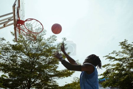 Téléchargez les photos : Joueur jetant la balle dans le panier lorsque vous jouez au basket en plein air - en image libre de droit