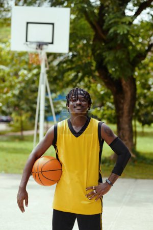Téléchargez les photos : Portrait de joueur de streetball noir souriant avec manchon de compression - en image libre de droit