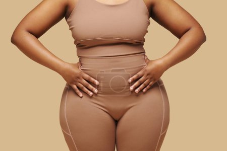 Téléchargez les photos : Cropped image of curvy Femme noire mettre les mains sur la taille - en image libre de droit