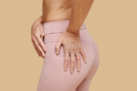 Foto de Fit woman touching her tight butt in pink leggings - Imagen libre de derechos