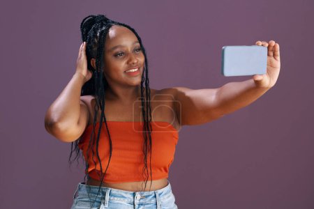 Téléchargez les photos : Sourire Jeune femme noire prenant selfie pour les médias sociaux - en image libre de droit
