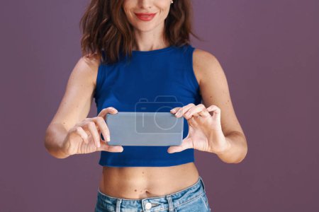 Photo for Cropped image of woman filming on smartphone - Royalty Free Image