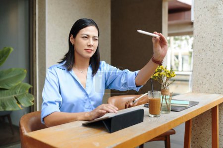 Téléchargez les photos : Femme créative assise à la table de café et dessin croquis sur tablette - en image libre de droit