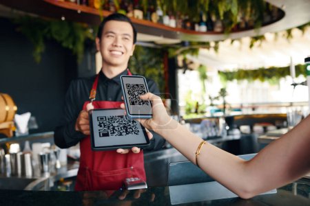Foto de Restaurante invitado escaneo qr código al pagar por la orden - Imagen libre de derechos