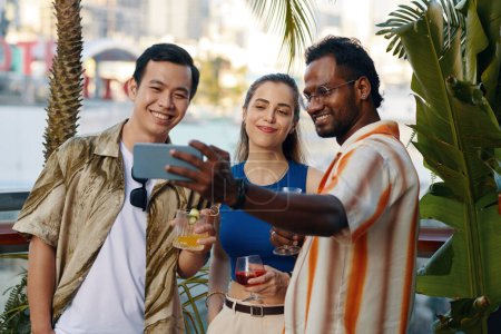 Téléchargez les photos : Homme indien heureux prenant selfie avec des amis à la fête dans le bar - en image libre de droit