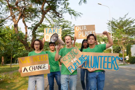 Group of young eco volunteers protesting with placards