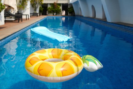 Téléchargez les photos : Anneau gonflable lumineux et matelas dans la piscine - en image libre de droit