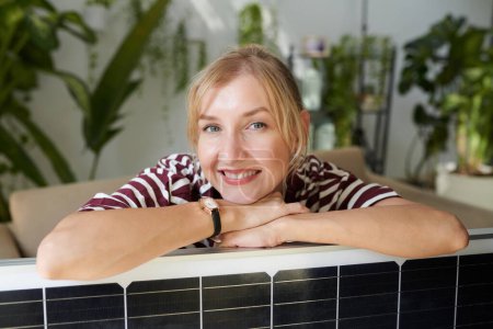 Photo for Portrait of cheerful woman leaning on solar panel she bought - Royalty Free Image