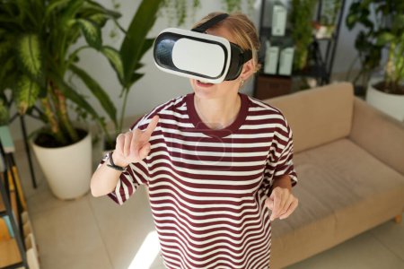 Téléchargez les photos : Femme en réalité virtuelle casque d'essai nouvelle interface - en image libre de droit