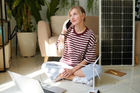 Photo for Smiling manager answering phone call, consulting client on solar panels and wind turbines - Royalty Free Image