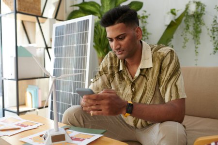Téléchargez les photos : Responsable des ventes d'énergies renouvelables répondant aux SMS des clients - en image libre de droit