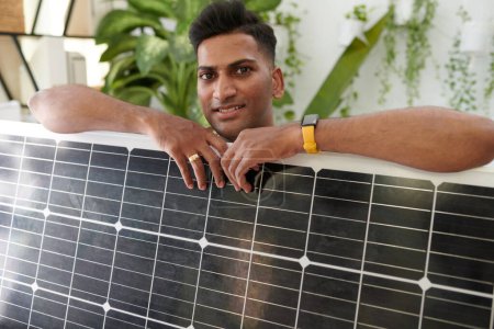 Téléchargez les photos : Portrait de client heureux posant avec le panneau solaire qu'il a acheté - en image libre de droit