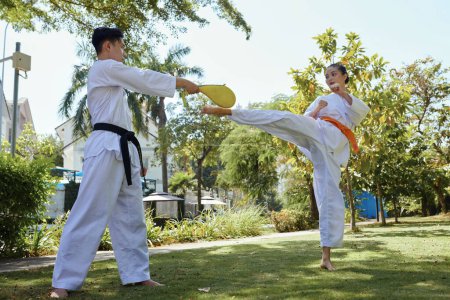 Photo for Taekwondo athlete kicking pad when practicing high kick - Royalty Free Image