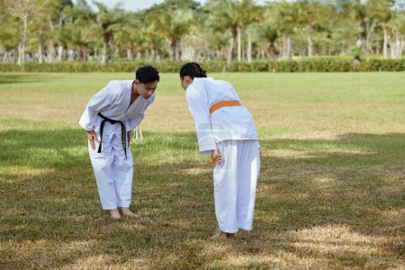 Photo for Taekwondo athletes bowing each other before sparring - Royalty Free Image