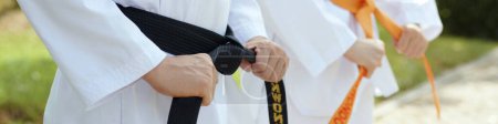 Téléchargez les photos : Bannière Web avec des athlètes de taekwondo attachant des ceintures avant le sparring - en image libre de droit
