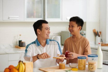 Photo for Happy Vietnamese father and son making sandwiches for breakfast - Royalty Free Image