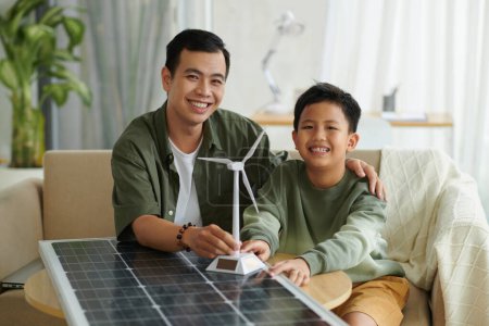 Foto de Retrato de padre e hijo felices aprendiendo sobre energías renovables - Imagen libre de derechos