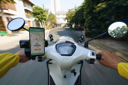Foto de POV de mototaxi conductor de montar rápido y comprobar las solicitudes en el teléfono inteligente - Imagen libre de derechos