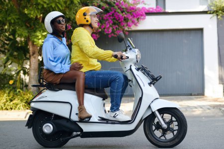 Téléchargez les photos : Heureuse femme noire utilisant un service de taxi moto pour se promener en ville - en image libre de droit