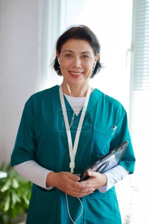 Téléchargez les photos : Portrait de médecin souriant avec tablette numérique travaillant pour le service de télémédecine - en image libre de droit