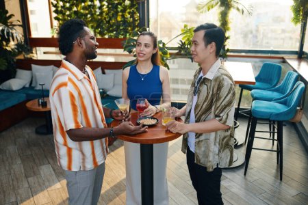Photo for Young people having snacks, drinking and talking at party - Royalty Free Image