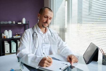 Téléchargez les photos : Portrait du médecin rédigeant la prescription - en image libre de droit