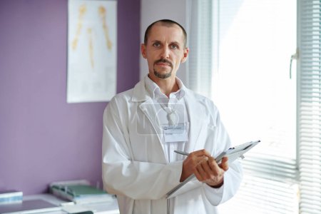 Porträt eines Arztes im weißen Laborkittel, der Notizen über ein Dokument macht