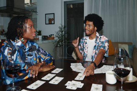 Photo for Black man spreading doing tarot spread for friend to reveal hidden information - Royalty Free Image