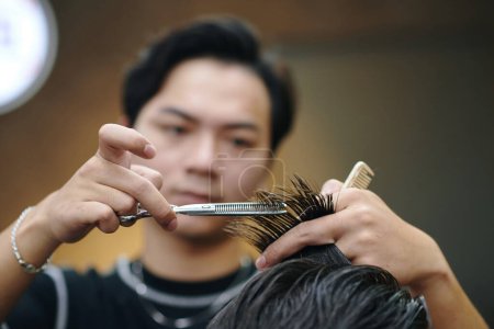 Friseur schneidet Haarteil mit Styling-Schere