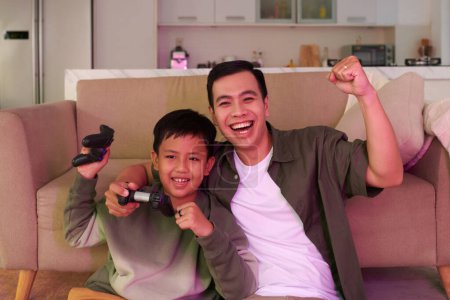 Alegre padre e hijo celebrando el videojuego ganador
