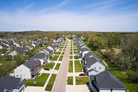Téléchargez les photos : A quiet neighborhood in Copley Ohio. Copley is located in Ohio, not far from Cleveland and Akron. Residential houses line the street, with a few cars in the drives. - en image libre de droit