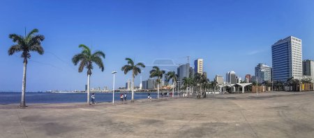 Luanda Angola - 09 17 2022: Panoramic view at the Luanda bay and Luanda marginal, pedestrian pathway with tropical palm trees, downtown lifestyle, Cabo Island, Port of Luanda and modern skyscrapers