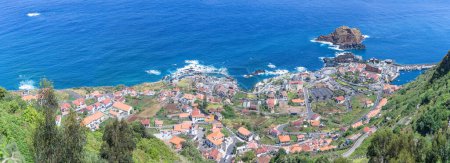 Foto de Isla de Madeira Portugal - 04 19 2023: Vista aérea panorámica del pueblo de Porto Moniz, vista completa del asentamiento principal de Porto Moniz e ilheu Mole, Isla de Madeira, Portugal - Imagen libre de derechos